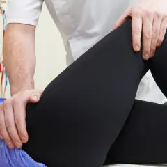 Fizjoterapeuta bada biodro pacjenta, co może pomóc w diagnozie choroby Otto-Chrobaka i jej przyczyn.
