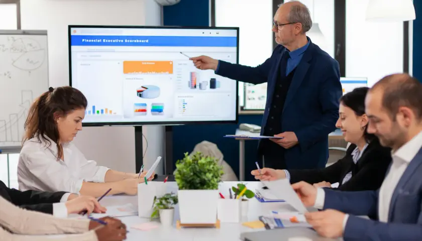 Zespół omawia wyniki na ekranie, jak wstawić link do prezentacji powerpoint.