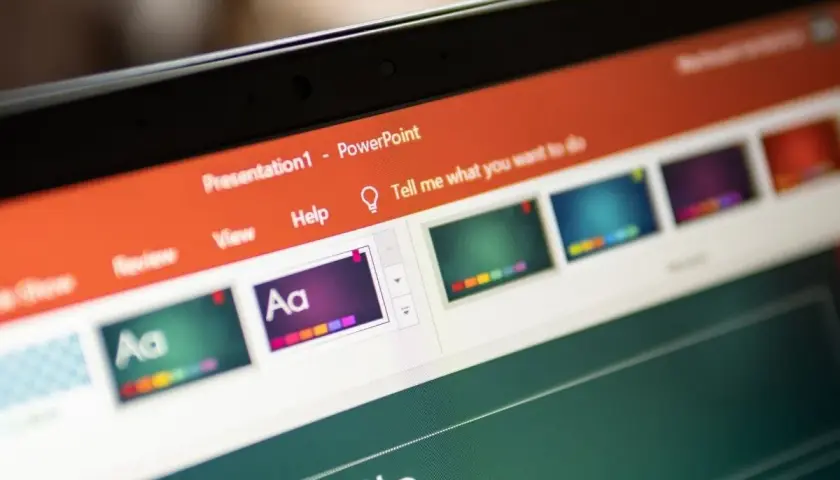 Ekran komputera z otwartym programem PowerPoint. Widoczne menu, miniaturki slajdów i pole tekstowe. Idealne do nauki, jak zrobić prezentacje w Powerpoincie.