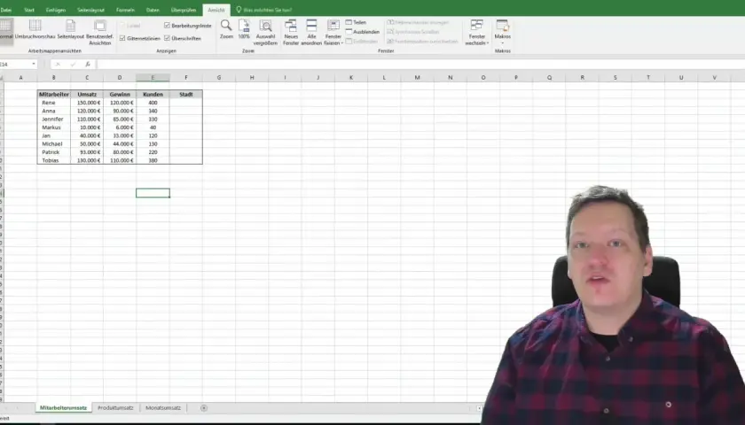 Mężczyzna w kratę siedzi przed arkuszem kalkulacyjnym Excel, gdzie dane pracowników są ułożone po kolei.