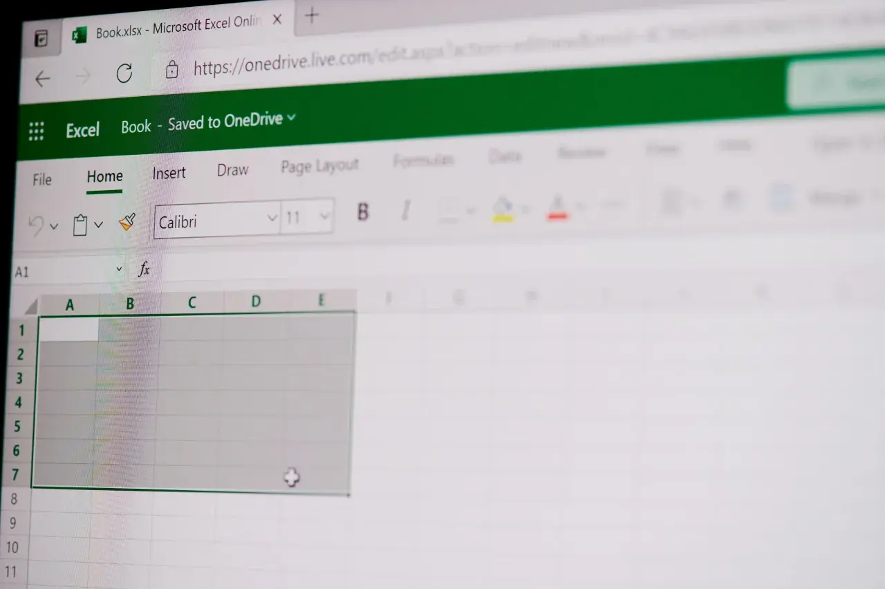 Ekran Excel Online z pustym arkuszem, gotowym do wprowadzania danych. Widoczne paski narzędzi i pole formuły, które ułatwiają pracę z funkcjami tablicowymi Excel.